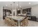 Spacious kitchen with a large island, pendant lighting, stainless steel appliances, and dark cabinetry at 8 Via Tiberina, Las Vegas, NV 89011