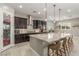 Modern kitchen with a large island, stainless appliances, dark cabinets, and walk-in pantry at 8 Via Tiberina, Las Vegas, NV 89011