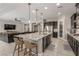 Open-concept kitchen with island seating, stainless steel appliances, and view into the living room at 8 Via Tiberina, Las Vegas, NV 89011