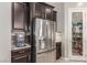 Stylish kitchen showcasing stainless steel refrigerator, walk-in pantry, and dark wood cabinetry at 8 Via Tiberina, Las Vegas, NV 89011