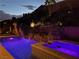 Night view of backyard pool with rock waterfall, water slide, and spa featuring colorful lighting at 8 Via Tiberina, Las Vegas, NV 89011