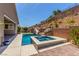 Backyard pool with a rock waterfall, waterslide, plants, hot tub, and brick pavers at 8 Via Tiberina, Las Vegas, NV 89011