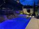 Backyard pool and spa with slide and rock waterfall featuring lush landscaping and lighting at 8 Via Tiberina, Las Vegas, NV 89011