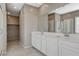 Bathroom boasts double sink vanity, a soaking tub with shower, tiled floor, neutral color walls, and walk in closet at 8486 Insignia Ave # 101, Las Vegas, NV 89178