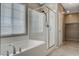 Bathroom boasts a soaking tub with shower, tiled floor, neutral color walls, and chrome fixtures and accessories at 8486 Insignia Ave # 101, Las Vegas, NV 89178