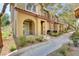 Charming townhome with covered porch, stone accents and desert landscaping, creating an inviting curb appeal at 8486 Insignia Ave # 101, Las Vegas, NV 89178