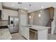 Bright kitchen features stainless appliances, granite countertops, a center island with sink, and white cabinets at 8486 Insignia Ave # 101, Las Vegas, NV 89178