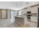 Open kitchen features white cabinets, stainless appliances, granite countertops, and a functional center island at 8486 Insignia Ave # 101, Las Vegas, NV 89178