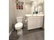 Bathroom with a tile floor, toilet, vanity with dual sinks, and decorative tiki statues at 8534 Insignia Ave # 101, Las Vegas, NV 89178