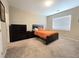 Spacious bedroom featuring a comfortable bed, dark dresser, and natural light from the window at 8534 Insignia Ave # 101, Las Vegas, NV 89178