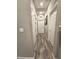 Hallway with wood-look floors, neutral paint, and doors that provide access to various rooms in the home at 8534 Insignia Ave # 101, Las Vegas, NV 89178