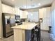 Bright kitchen features white cabinets, stainless steel appliances, granite countertops, and an island with bar stool seating at 8534 Insignia Ave # 101, Las Vegas, NV 89178