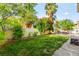 Backyard with grass and a patio seating area under a bright sky at 8612 Danza Del Sol Dr, Las Vegas, NV 89128
