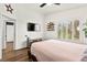Bright bedroom featuring wood floors, shutters, and a ceiling fan at 8612 Danza Del Sol Dr, Las Vegas, NV 89128