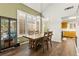 Dining room with hardwood floors, plantation shutters, stylish lighting, and adjacent kitchen at 8612 Danza Del Sol Dr, Las Vegas, NV 89128