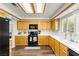 Bright kitchen with white counters, wooden cabinets, and black appliances at 8612 Danza Del Sol Dr, Las Vegas, NV 89128