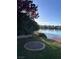 Backyard with a lake view, green grass, and fire pit at 8740 Captains Pl, Las Vegas, NV 89117