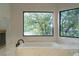 Modern bathroom with soaking tub under windows offering a lake view at 8740 Captains Pl, Las Vegas, NV 89117