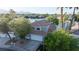 Exterior view of a two-story home on a lake with palm trees and mature trees at 8740 Captains Pl, Las Vegas, NV 89117