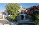 Stucco house with well-manicured front yard and mature trees providing shade at 8740 Captains Pl, Las Vegas, NV 89117