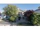 Two-story stucco home with a balcony, manicured lawn, and mature trees at 8740 Captains Pl, Las Vegas, NV 89117