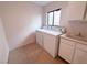 Bright laundry room with washer, dryer, and utility sink provides convenience and functionality at 8740 Captains Pl, Las Vegas, NV 89117