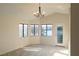 Living room featuring neutral carpet, three windows with lake views, and a glass panel door at 8740 Captains Pl, Las Vegas, NV 89117