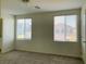 Comfortable bedroom with plush carpeting, natural lighting, and two windows overlooking the neighborhood at 8793 Candelabra Ct, Las Vegas, NV 89148