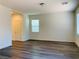 Sunlit living room with wood-look floors and neutral walls with window and door at 8793 Candelabra Ct, Las Vegas, NV 89148