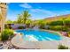 Backyard pool featuring a rock waterfall surrounded by mature landscaping at 8928 Rusty Rifle Ave, Las Vegas, NV 89143