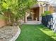 Charming backyard area with artificial turf and covered patio with elegant columns at 8931 Lansberry Ct, Las Vegas, NV 89147