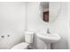 Half bathroom with a pedestal sink and a round mirror at 9173 Weeping Hollow Ave, Las Vegas, NV 89178