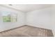 Bright bedroom with neutral carpet, white walls, and a large window at 9173 Weeping Hollow Ave, Las Vegas, NV 89178