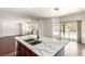 Kitchen island with quartz countertops and a view of the backyard pool through sliding glass doors at 9173 Weeping Hollow Ave, Las Vegas, NV 89178