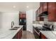 Modern kitchen with stainless steel appliances, quartz countertops, and dark wood cabinets at 9173 Weeping Hollow Ave, Las Vegas, NV 89178