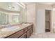 Bright bathroom featuring double sinks, large mirror, tile flooring, and shower/tub at 9305 Hollycrest Dr, Las Vegas, NV 89117