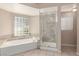 Bathroom with a soaking tub, glass block window, and a glass enclosed shower at 9305 Hollycrest Dr, Las Vegas, NV 89117