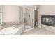 Bathroom featuring a soaking tub, glass shower, and a fireplace at 9305 Hollycrest Dr, Las Vegas, NV 89117