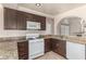 Well-lit kitchen featuring granite countertops, white appliances, and dark wood cabinets at 9305 Hollycrest Dr, Las Vegas, NV 89117