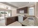Well-lit kitchen featuring granite countertops, white appliances, and dark wood cabinets at 9305 Hollycrest Dr, Las Vegas, NV 89117