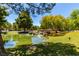 Scenic pond with lush greenery, mature trees, and tranquil water features, creating a serene and natural environment at 9305 Hollycrest Dr, Las Vegas, NV 89117