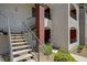 Exterior view of a modern condo featuring a staircase leading to upper-level units and red painted doors at 950 Seven Hills Dr # 1624, Henderson, NV 89052