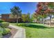 Landscaped front yard with lush lawn, trees, and concrete walkway leading to the home, under a clear blue sky at 950 Seven Hills Dr # 1624, Henderson, NV 89052