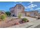 Home exterior showing a two-car garage, desert landscaping, and a red tile roof at 1025 Clover Tip Ct, Las Vegas, NV 89123