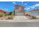 Two-story home showcasing a neutral stucco facade, red tile roof, well-kept landscaping, and an attached two-car garage at 1025 Clover Tip Ct, Las Vegas, NV 89123