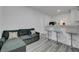 Small kitchen with white cabinetry, bar top, and adjacent seating area at 1025 Clover Tip Ct, Las Vegas, NV 89123