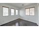 Well-lit bedroom with dark wood floors and natural light from three windows with wood trim at 1069 Coronado Peak Ave, Las Vegas, NV 89183