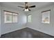 Bright bedroom with a ceiling fan, wood-look floors, and two windows at 1069 Coronado Peak Ave, Las Vegas, NV 89183