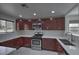 Modern kitchen with cherry wood cabinets, stainless steel appliances, and white quartz countertops at 1069 Coronado Peak Ave, Las Vegas, NV 89183
