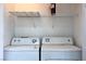 Compact laundry area featuring a white washer and dryer with a shelf above for storage at 1069 Coronado Peak Ave, Las Vegas, NV 89183